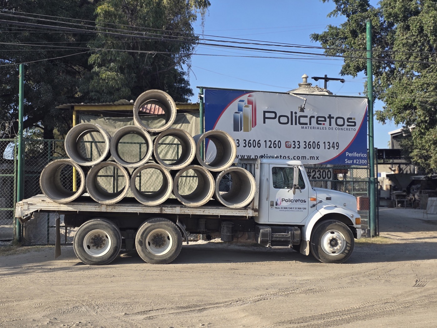 Camión de Policretos cargado con tubo de concreto frente a la planta